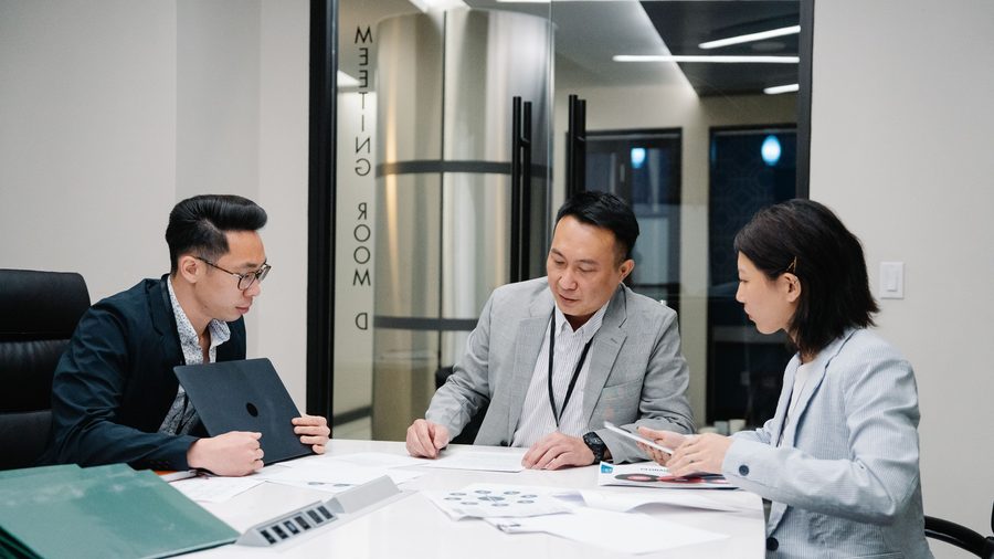 컨설턴트와 담당자가 회의실에서 현황 자료를 검토하는 모습